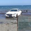 Imagen compartida por la Policía Local de Santa Pola, donde aparece la fotografía del coche aparcado en la orilla de una playa y la notificación de la multa.