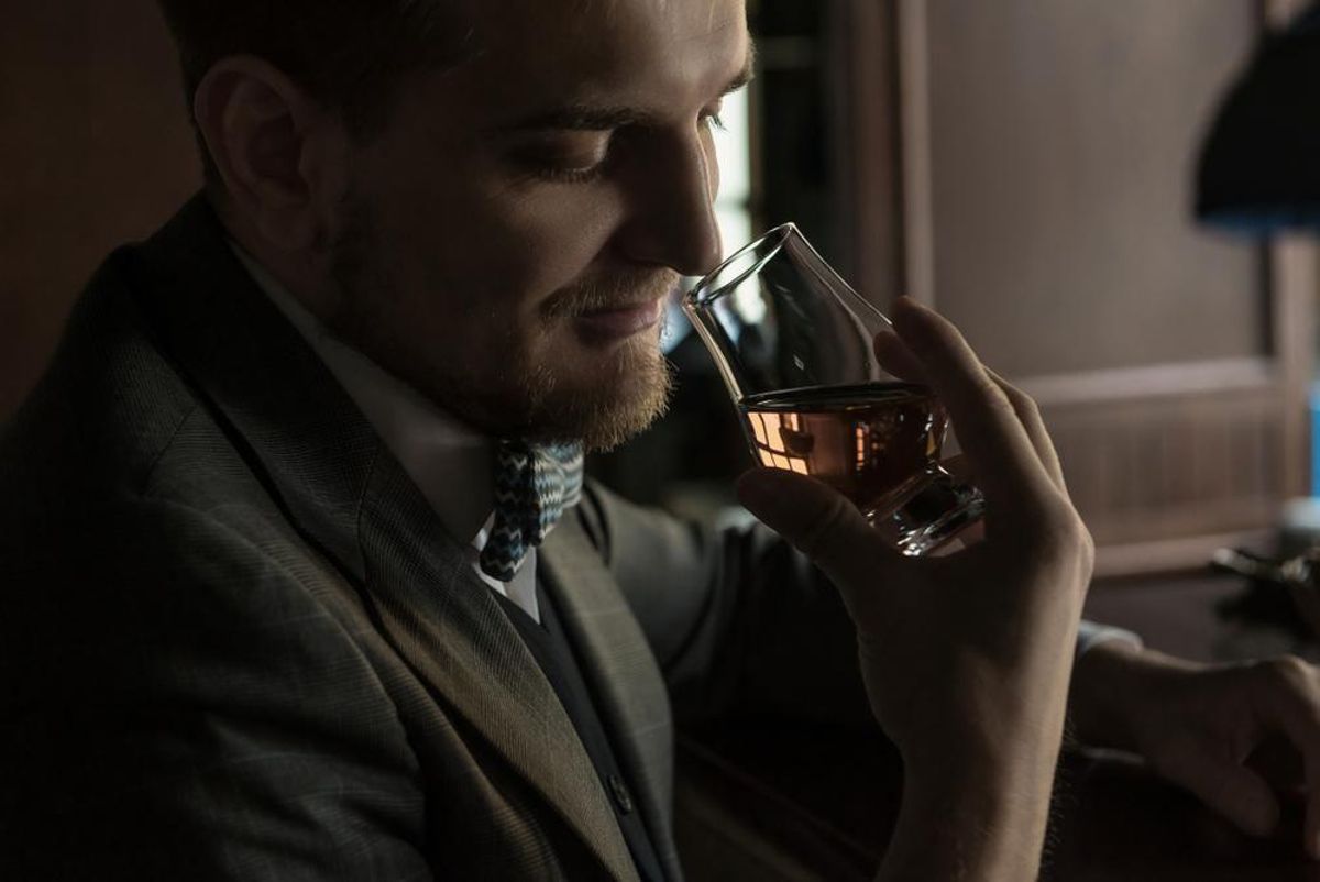 Una imagen de archivo de una persona oliendo un whisky. Una imagen de archivo de una persona oliendo un whisky.