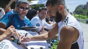 Karim Benzema firma autógrafos a los aficionados durante el último entrenamiento
