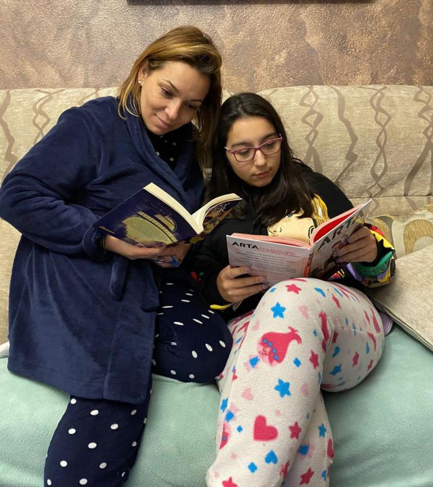 Débora Ríos y su hija Uxía, leyendo un libro. / CEDIDA