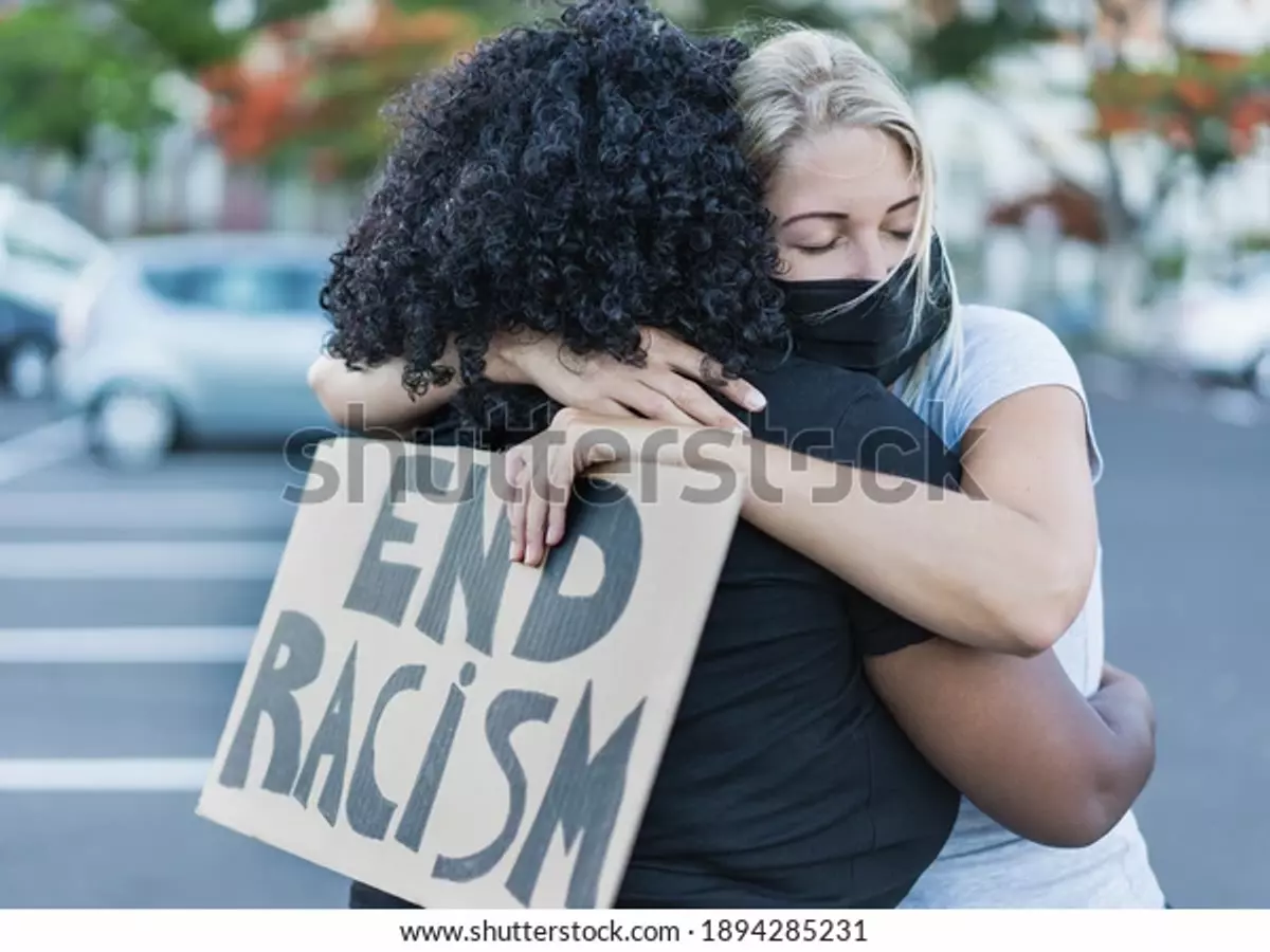 Una mujer africana abraza a una mujer caucásica durante una manifestación contra el racismo.