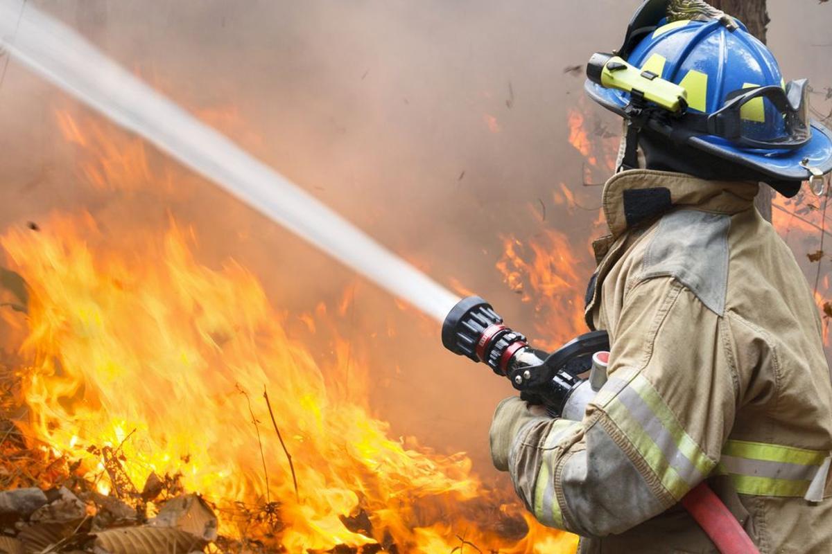 Un bombero combate un fuego. Un bombero combate un fuego.