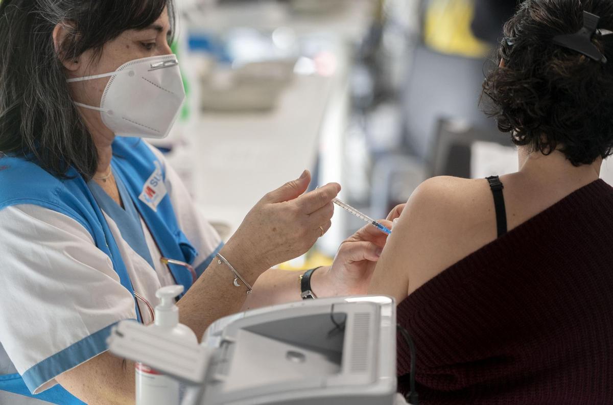 Una mujer recibe la tercera dosis de la vacuna contra el Covid-19, en el WiZink Center, a 20 de enero de 2022, en Madrid, (España). Hoy arranca, en la red de hospitales públicos de la Comunidad de Madrid  la inoculación de la tercera dosis de la vacuna co