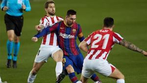 Messi se lleva un balón entre Iñigo Martínez y Capa