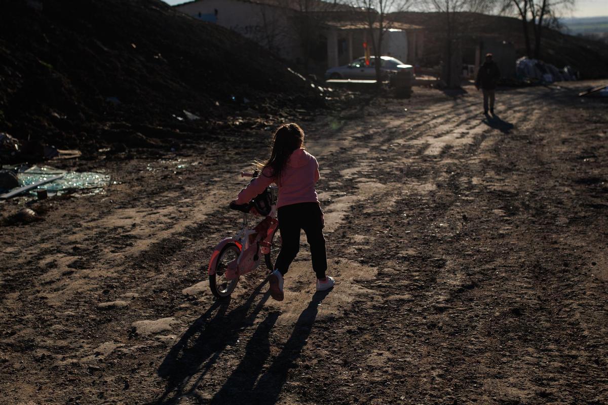 Una niña con una bicicleta en el sector VI de la Cañada Real.