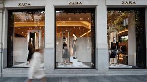 Una mujer pasa por delante del escaparate de una tienda de Zara.