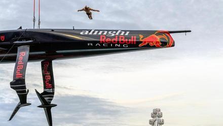 El equipo Alinghi Red Bull Racing de la Copa América de vela abre su base en el Port Vell con un espectáculo de saltos desde el barco AC75