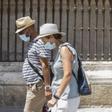 Archivo - Dos personas caminan con mascarilla y sombrero durante una ola de calor africano.