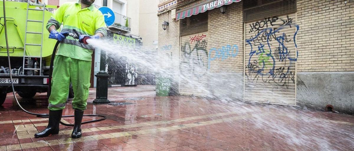 Un operario de FCC limpia con agua a presión una calle del centro de Zaragoza. |