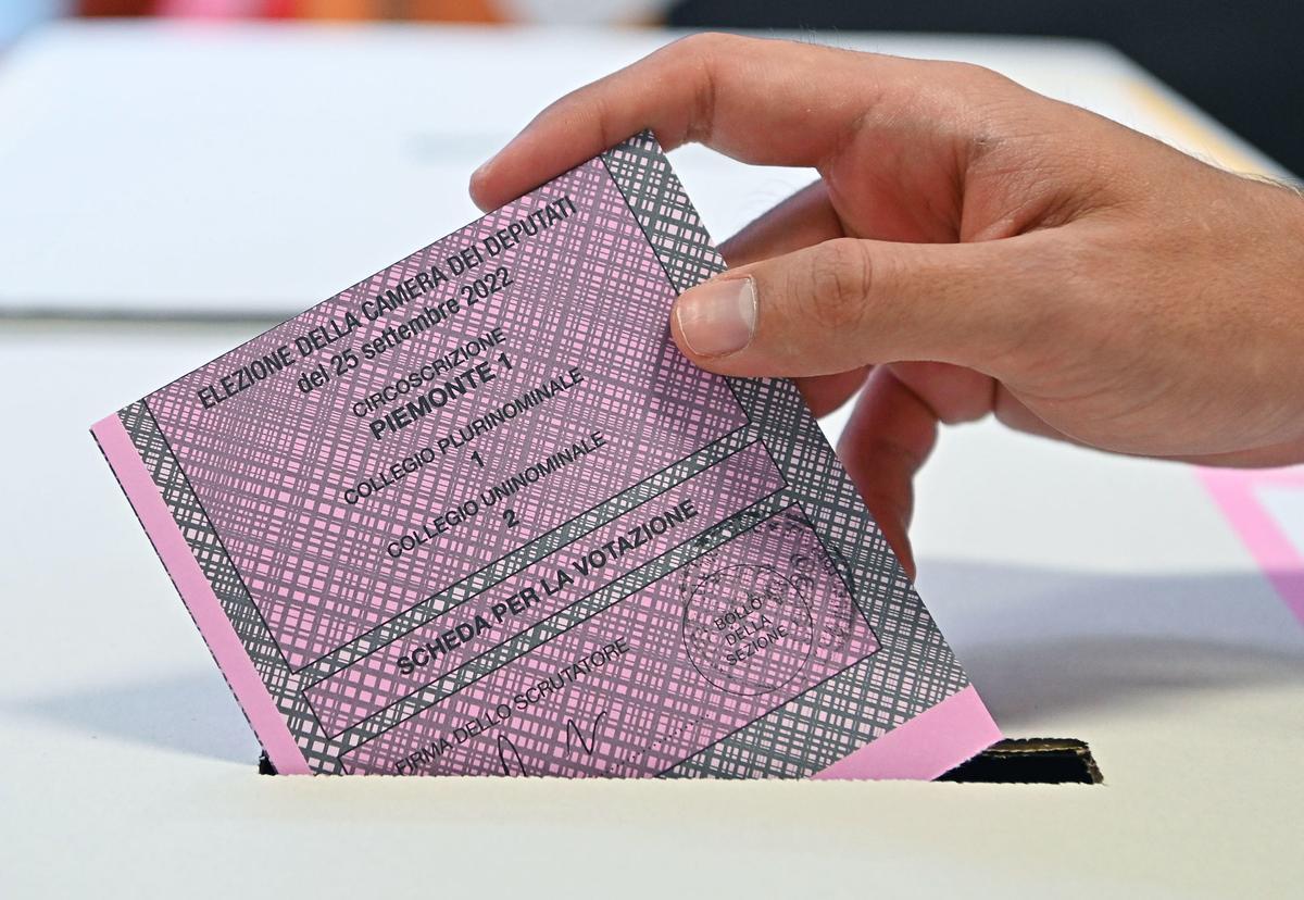 Un hombre deposuta un voto en una urna durante las eleciones italianas.
