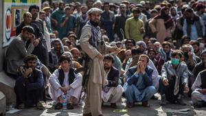 Archivo - Un miliciano talibán guarda la cola para retirar dinero en Kabul, Afganistán.