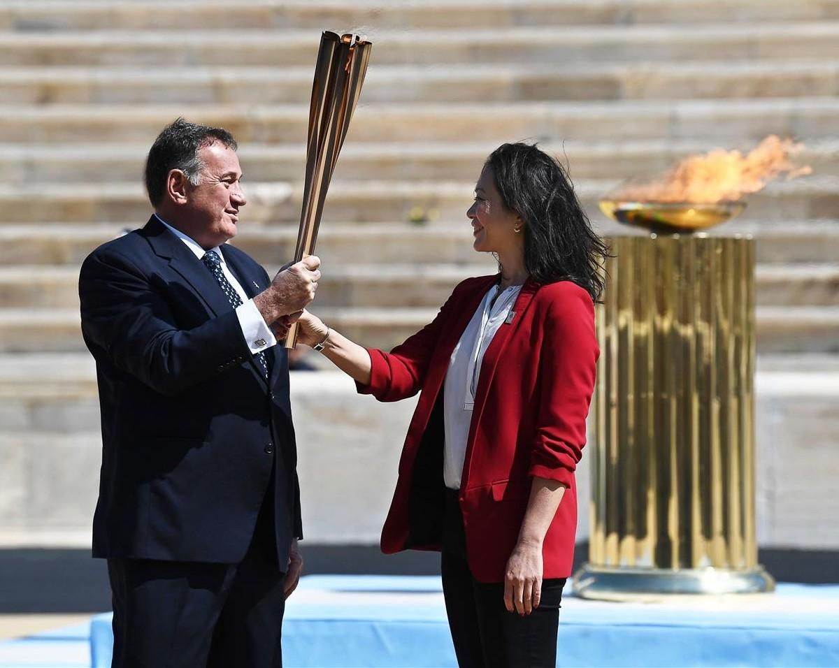 Spyros Capralos, presidente del Comité Olímpico Helénico, entrega la antorcha olímpica a la ex nadadora japonesa Naoko Imoto durante la ceremonia de entrega de la llama olímpica en el Estadio Panatenaico de Atenas Spyros Capralos, presidente del Comité Olímpico Helénico, entrega la antorcha olímpica a la ex nadadora japonesa Naoko Imoto durante la ceremonia de entrega de la llama olímpica en el Estadio Panatenaico de Atenas