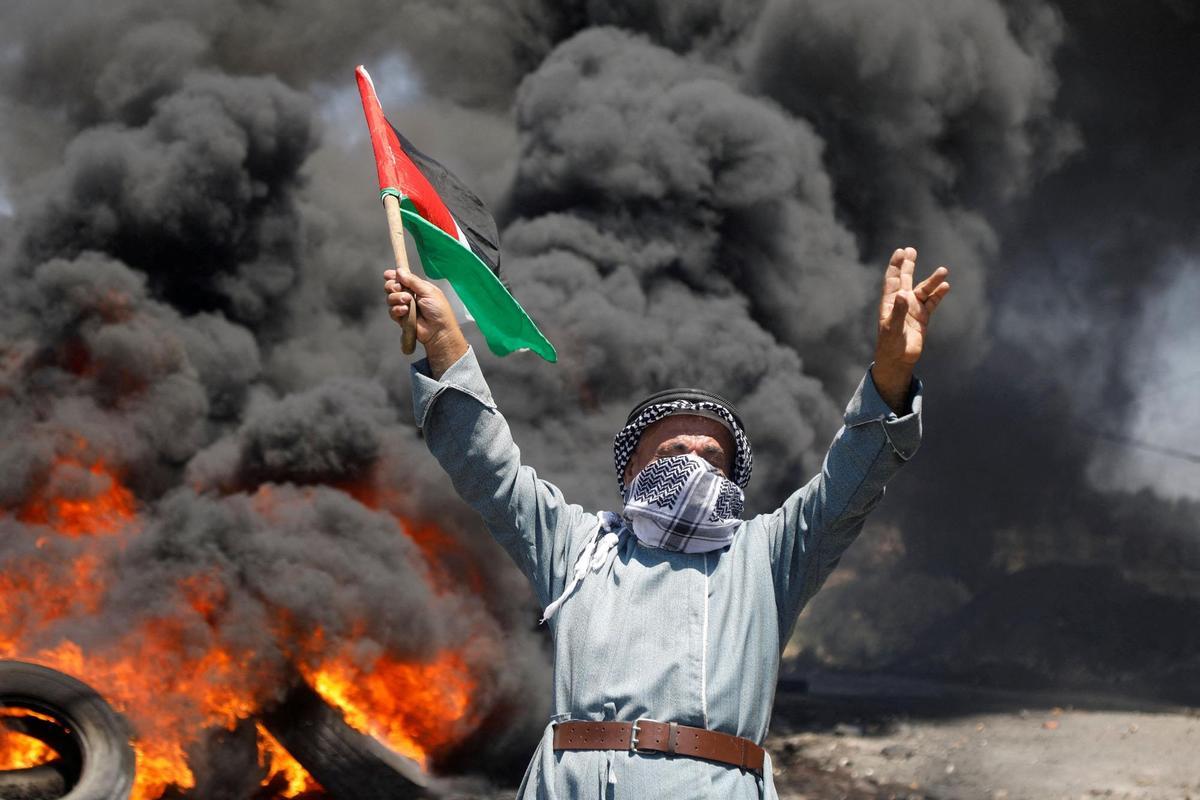 Un manifestante porta una bandera palestina durante una protesta contra las actividades de Israel en el asentamiento de Kafr Qaddum.
