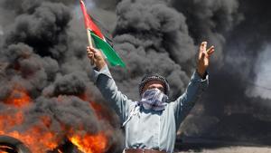 Un manifestante porta una bandera palestina durante una protesta contra las actividades de Israel en el asentamiento de Kafr Qaddum.