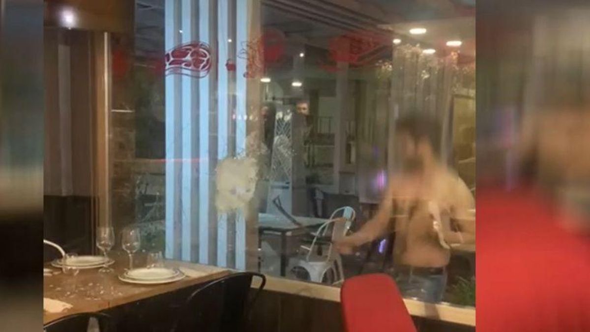 El joven, mientras trata de romper el cristal de un local en Bullas. / L.O. El joven, mientras trata de romper el cristal de un local en Bullas. / L.O.