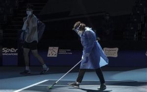 El japonés Taro Daniel pasa junto a un miembro del personal del torneo mientras limpia una cancha del Abierto de Singapur El japonés Taro Daniel pasa junto a un miembro del personal del torneo mientras limpia una cancha del Abierto de Singapur