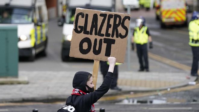 Un joven aficionado con una pancarta contra los Glazer Un joven aficionado con una pancarta contra los Glazer