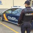 Archivo - Un agente de la Policía Nacional en Palma junto al coche policial.