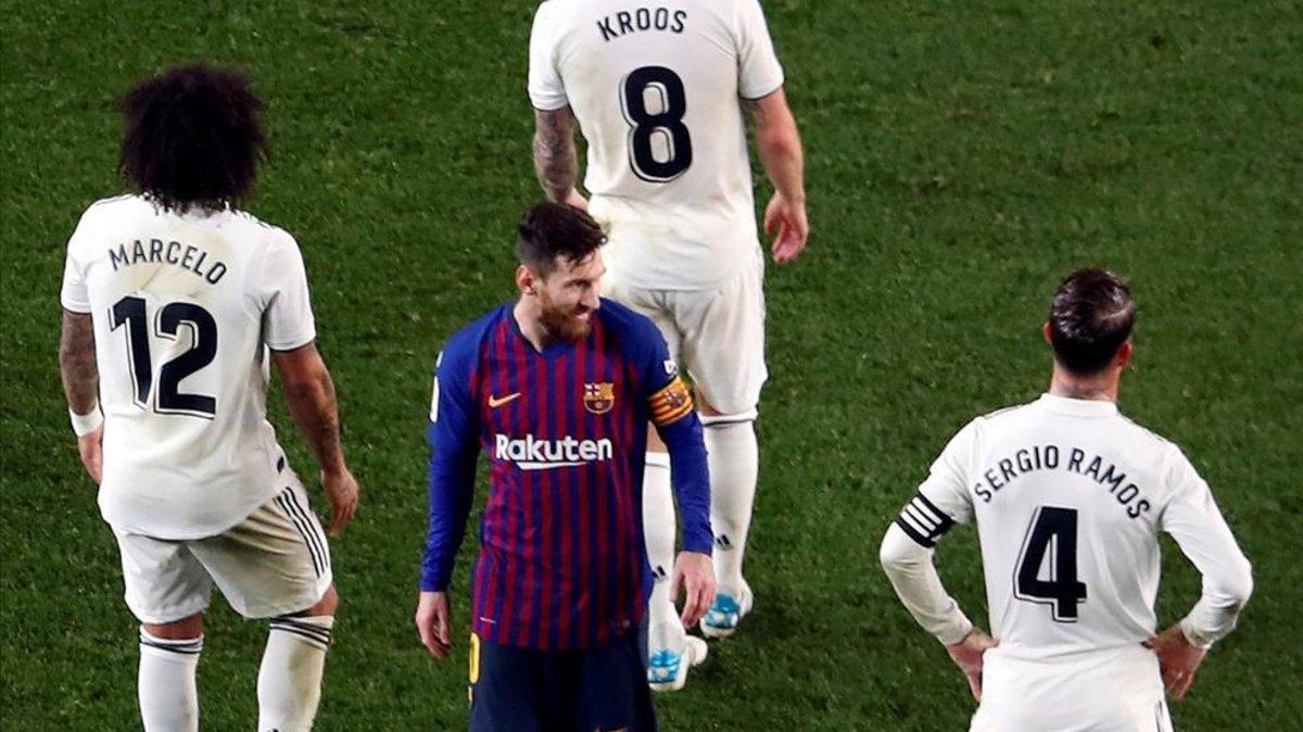 Leo Messi rodeado por tres jugadores del Real Madrid