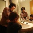 Una madre con las actividades cotidianas del cuidado de sus hijos.