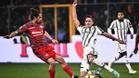Castagnetti, de la Cremonese, intenta quitarle el balón a Milik, de la Juventus