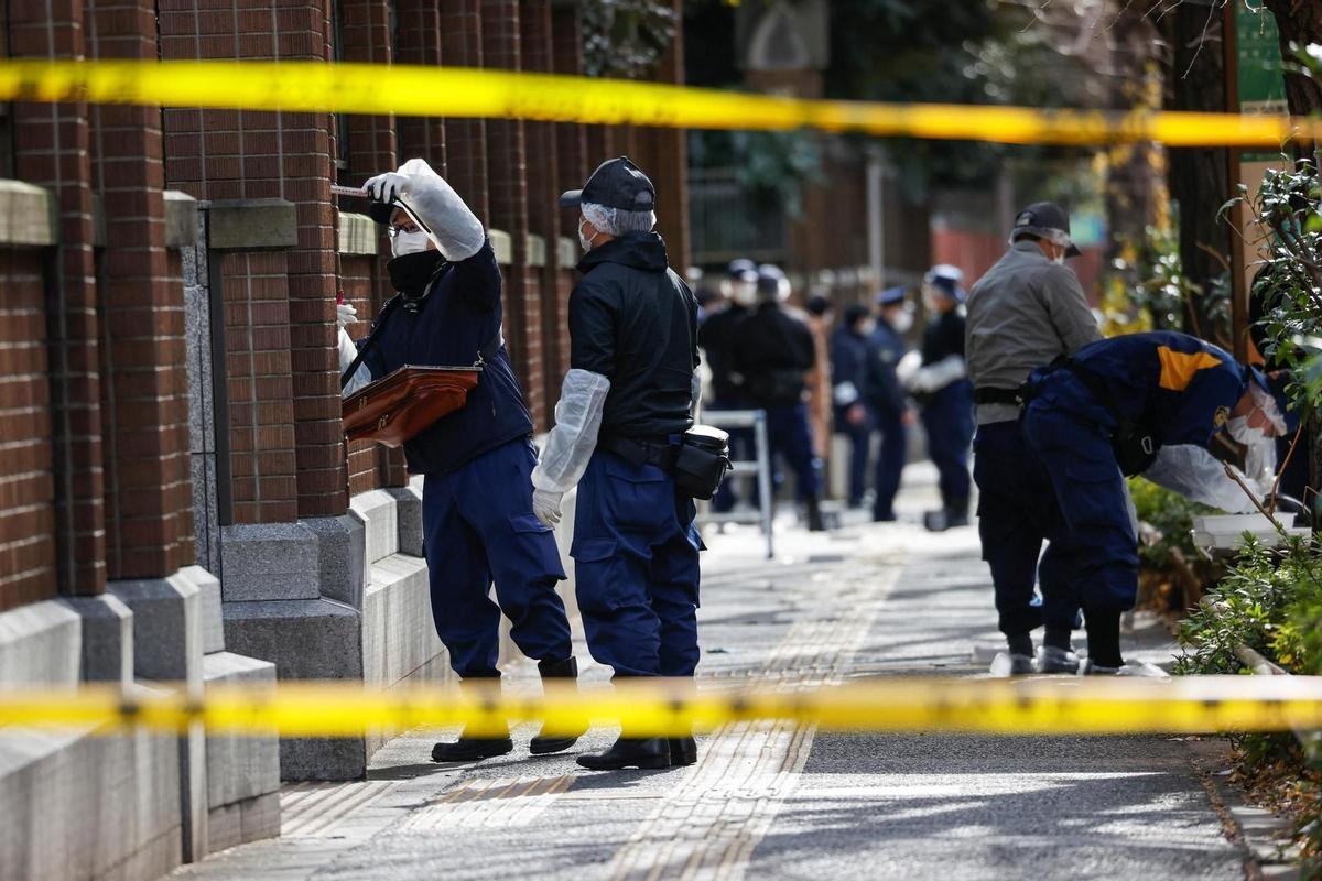 Police officers inspect an area at Tokyo University after a stabbing incident, in Tokyo