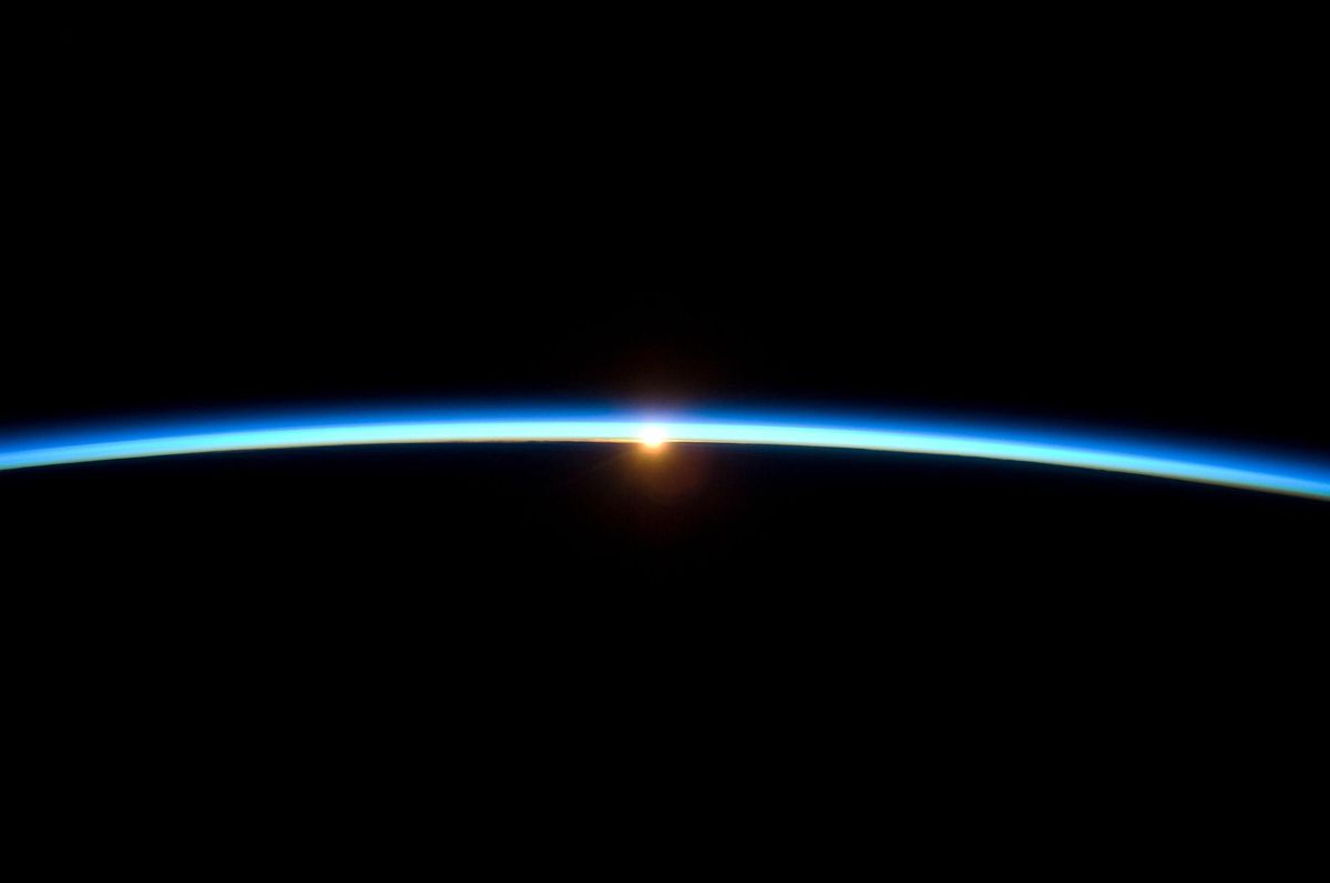 La delgada atmósfera de la Tierra al atardecer , con la silueta de la Tierra.