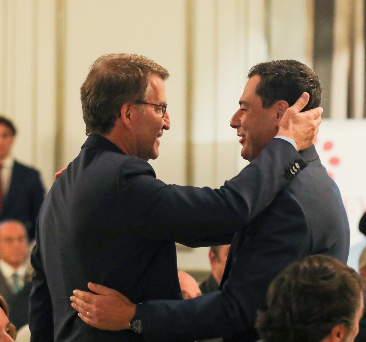El presidente del Partido Popular, Alberto Núñez Feijóo, y el presidente de la Junta de Andalucía, Juanma Moreno, se saludan a su llegada al Foro Joly, en el Hotel Westin Palace, a 19 de septiembre de 2022, en Madrid (España).