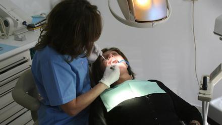 Una dentista atiende a una paciente.
