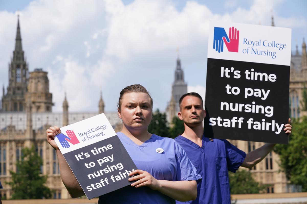 Archivo - Personal de enfermería sujetan pancartas en el exterior del Real Colegio de Enfermería británico en Londres.
