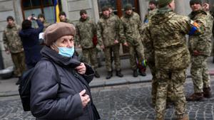 Una mujer pasa frente a un grupo de soldados en kiev.