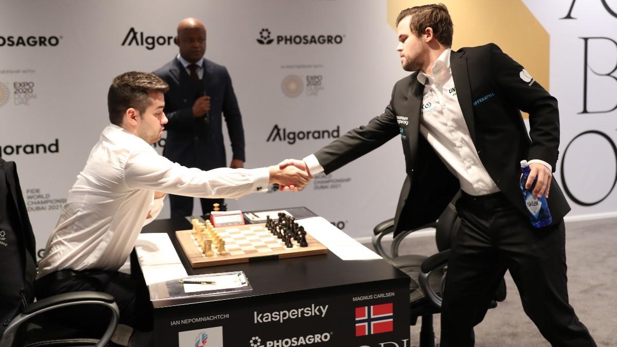 Carlsen (derecha) saluda a Nepo (izquierda) antes de la novena partida.