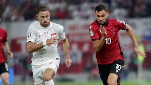 Cash y Bajrami disputan un balón en el Albania - Polonia