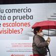 Una mujer camina junto a una sucursal del Banco Santander.