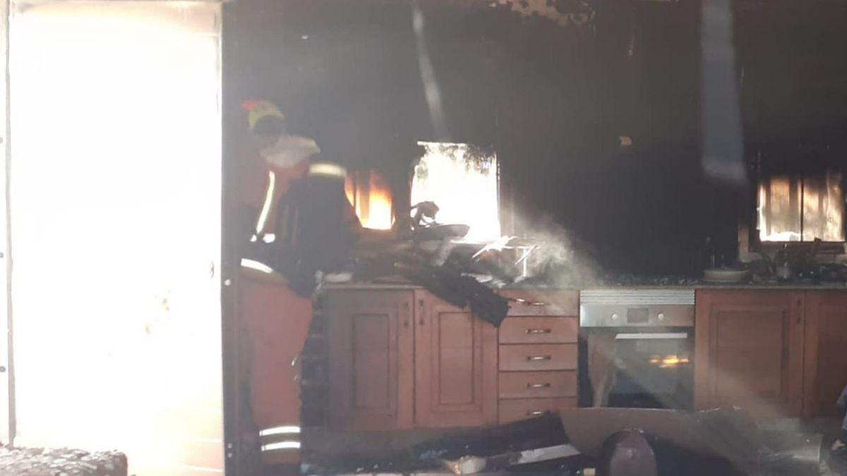 Un bombero trabaja en la extinción del incendio que hoy se ha cobrado la vida de una persona en Alzira.
