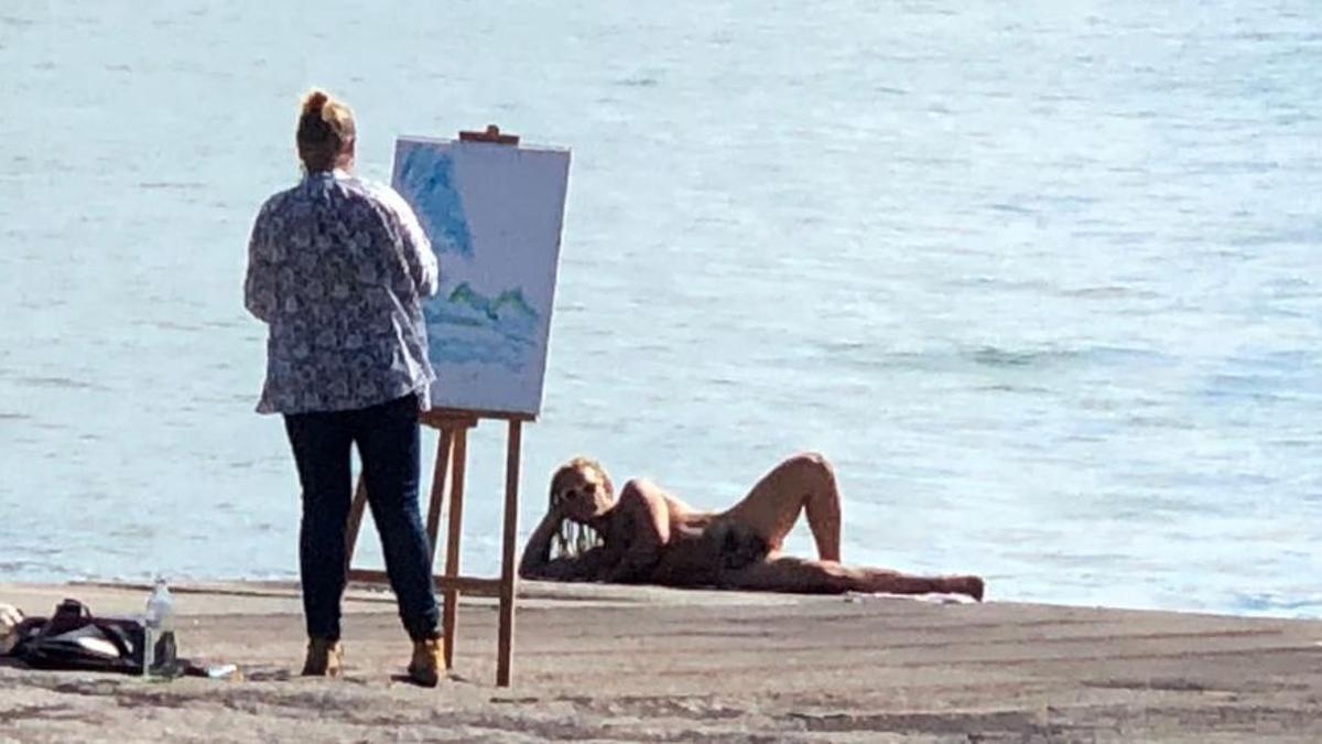 Un hombre posa desnudo en Tazacorte frente a la nueva fajana del volcán de La Palma