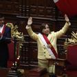 La abogada Dina Boluarte saluda tras ser juramentada como nueva presidenta del Perú por el presidente del Congreso, José Daniel Williams Zapata.