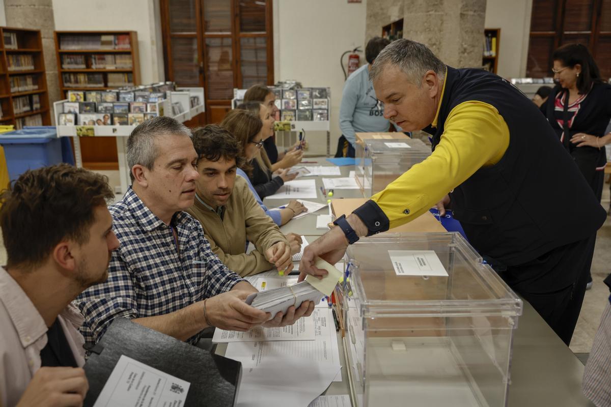 Un cartero entrega los votos emitidos por correo en una mesa electoral de Valencia.